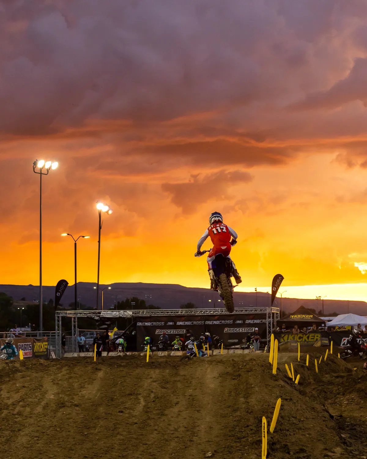 Arenacross rider in the air against a fiery orange sunset in Grand Junction