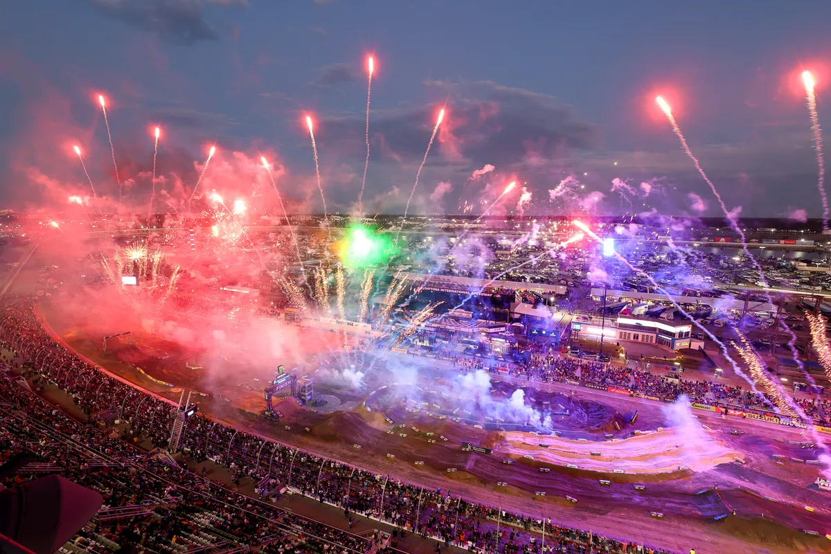 Fireworks bursting over the Supercross track and grandstands at Daytona International Speedway at dusk
