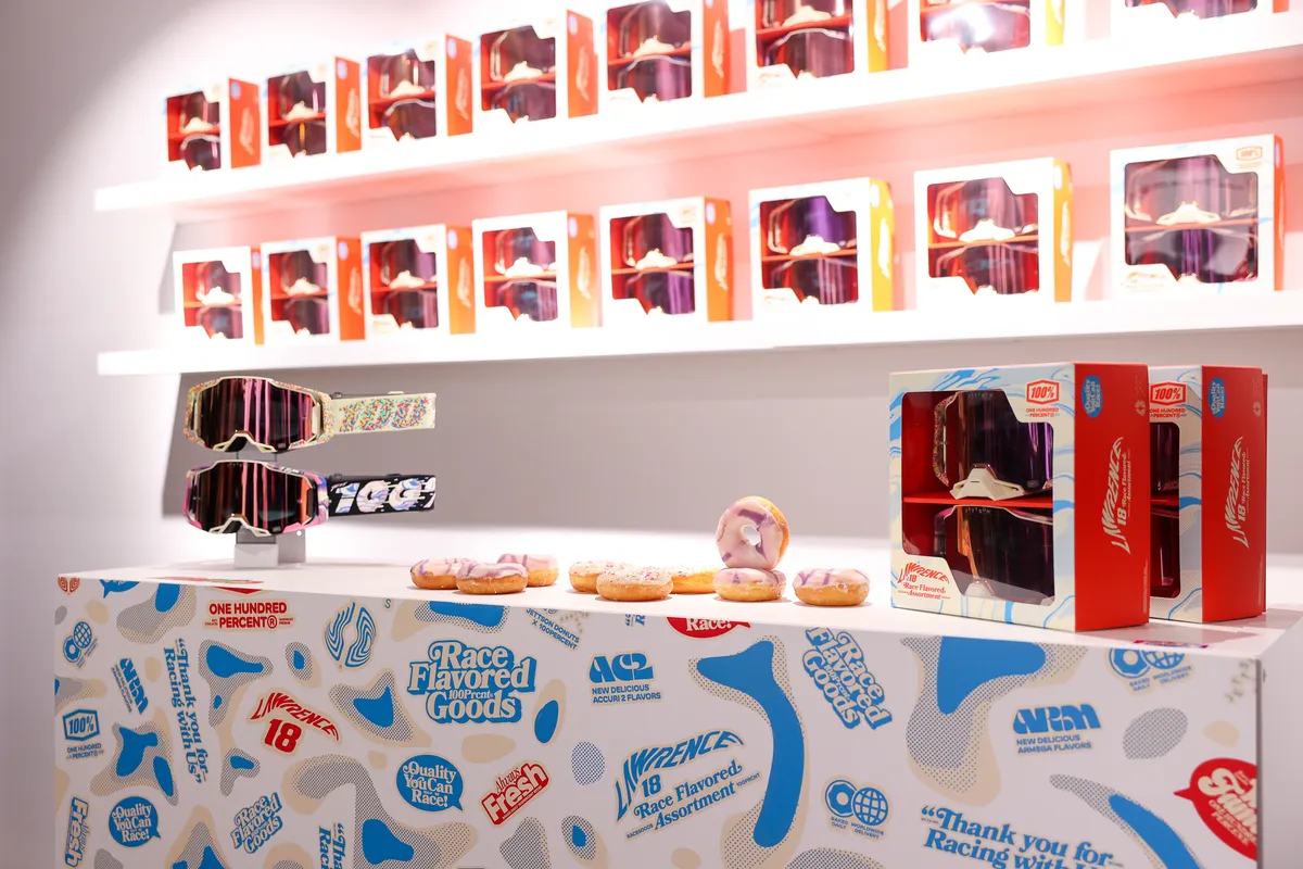 Goggle launch counter with boxed goggles on lit shelves, donuts and a patterned display wrap