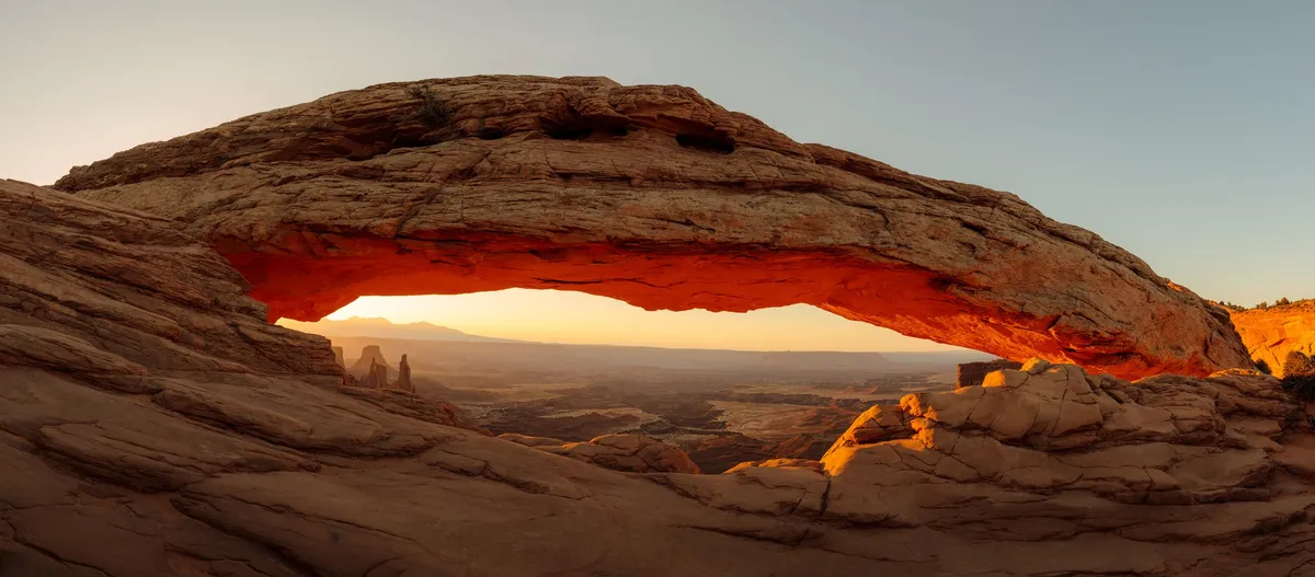 Mesa Arch glowing orange at sunrise, Canyonlands National Park