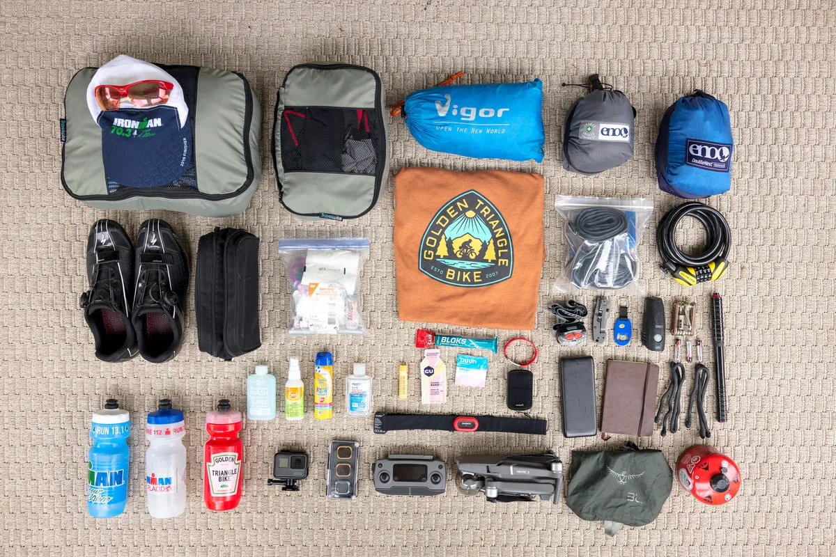 Flat-lay of all the trip's camping, cycling and camera gear laid out on a carpet