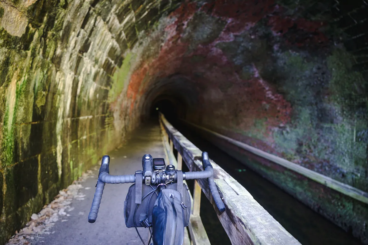 Handlebars and bar bag on the wooden boardwalk heading into the Paw Paw tunnel