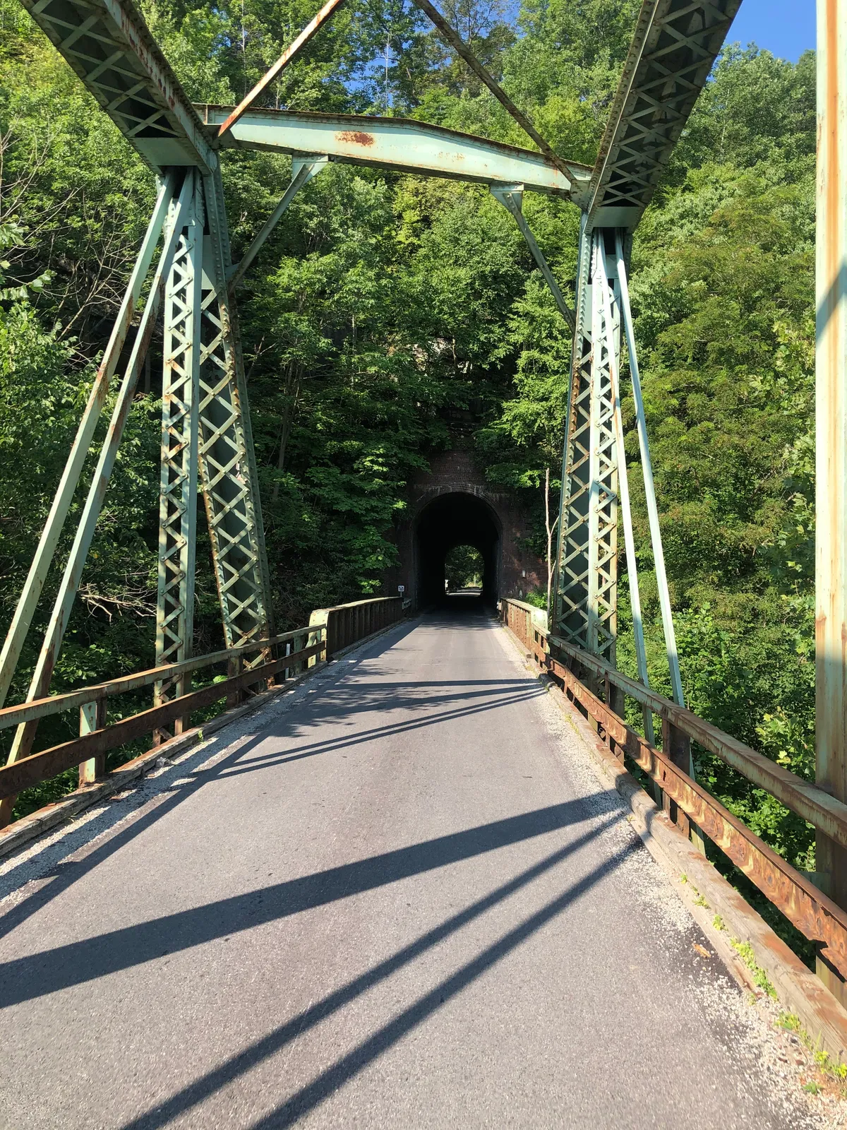 Ground view through the green Layton truss bridge into the tunnel portal