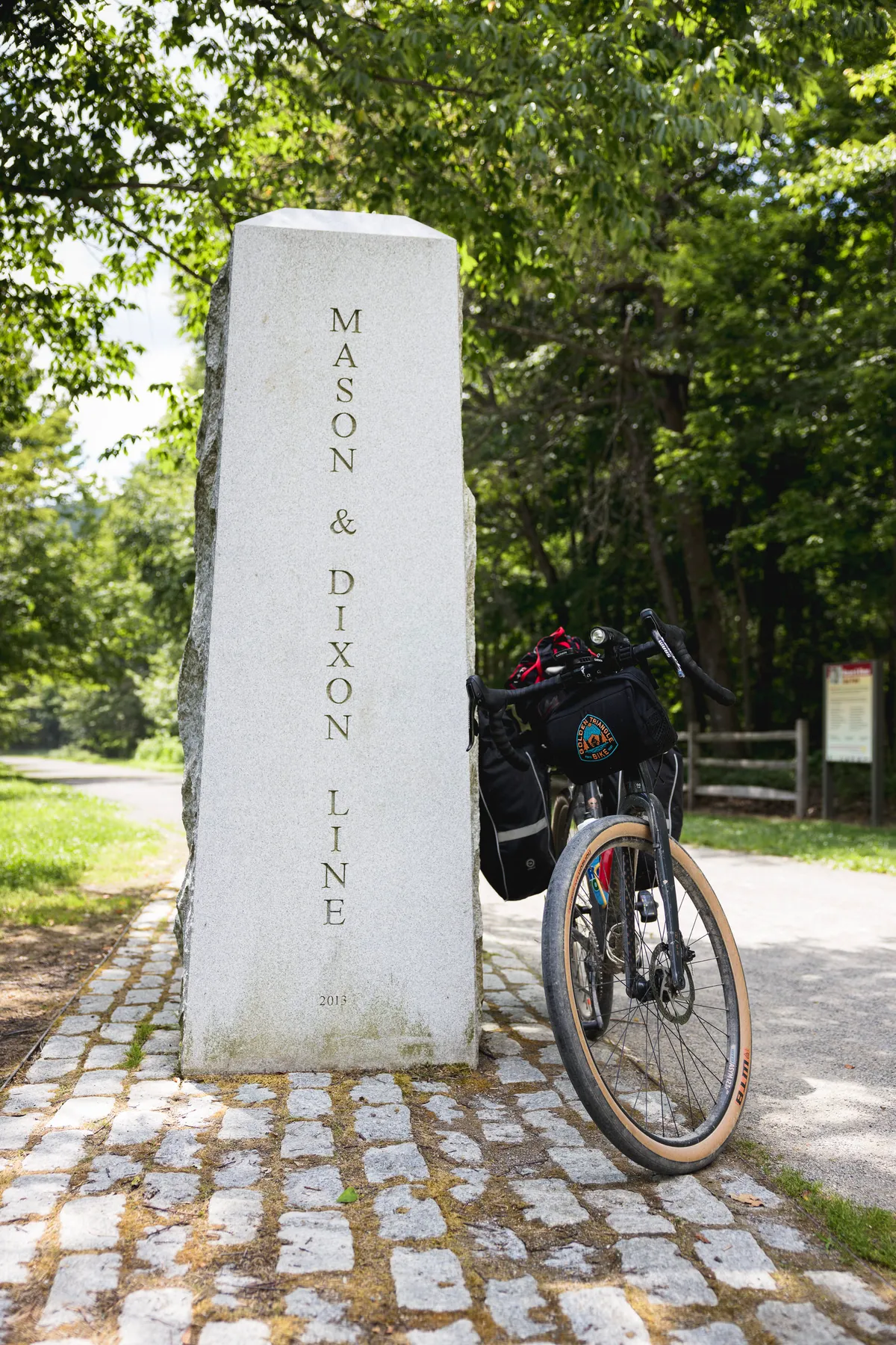 Mason & Dixon Line obelisk with a loaded bike leaning on it