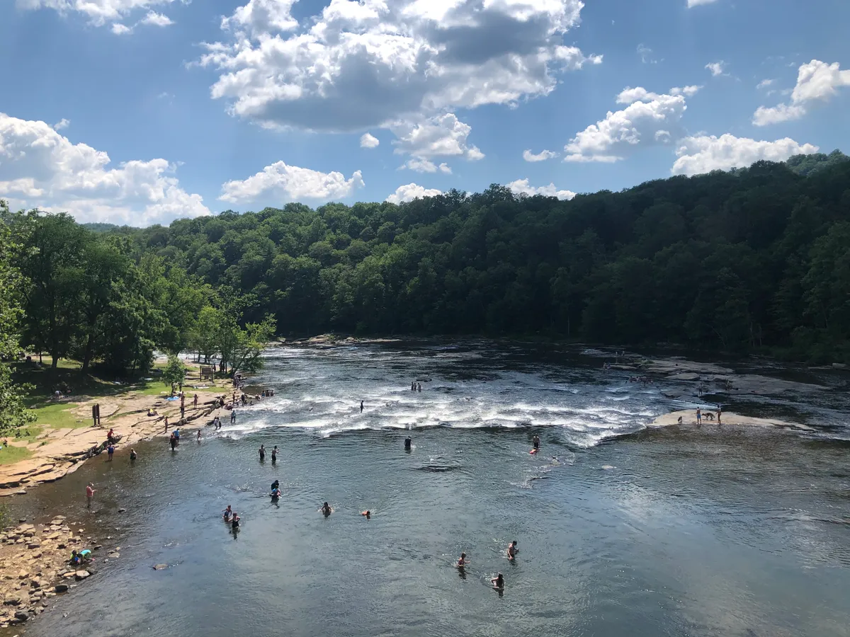 Wide river shallows at Ohiopyle full of people wading