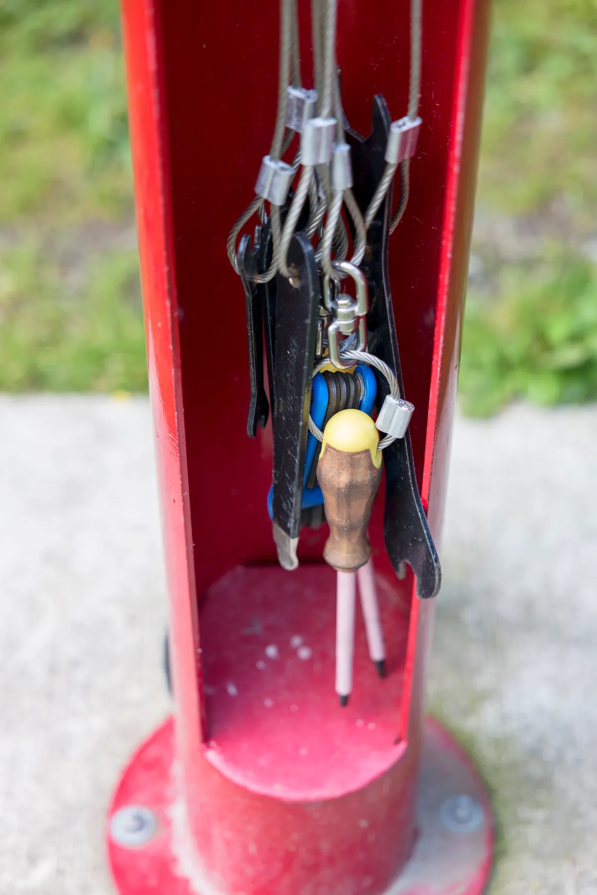 Close-up of tools hanging on a red bike repair stand
