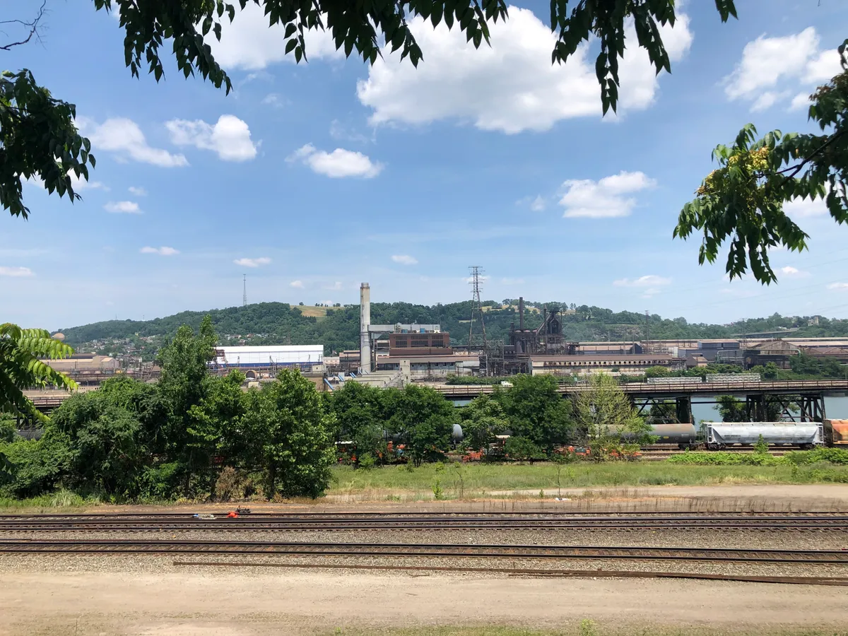 Steel mill across a rail yard under blue sky