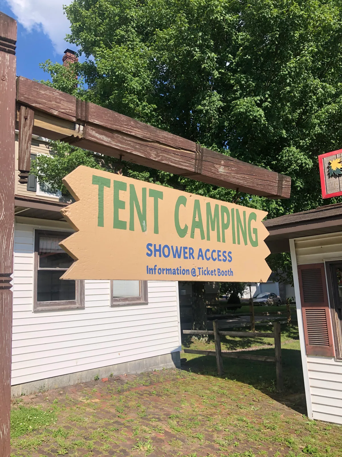 Wooden arrow sign in Meyersdale pointing to tent camping and shower access