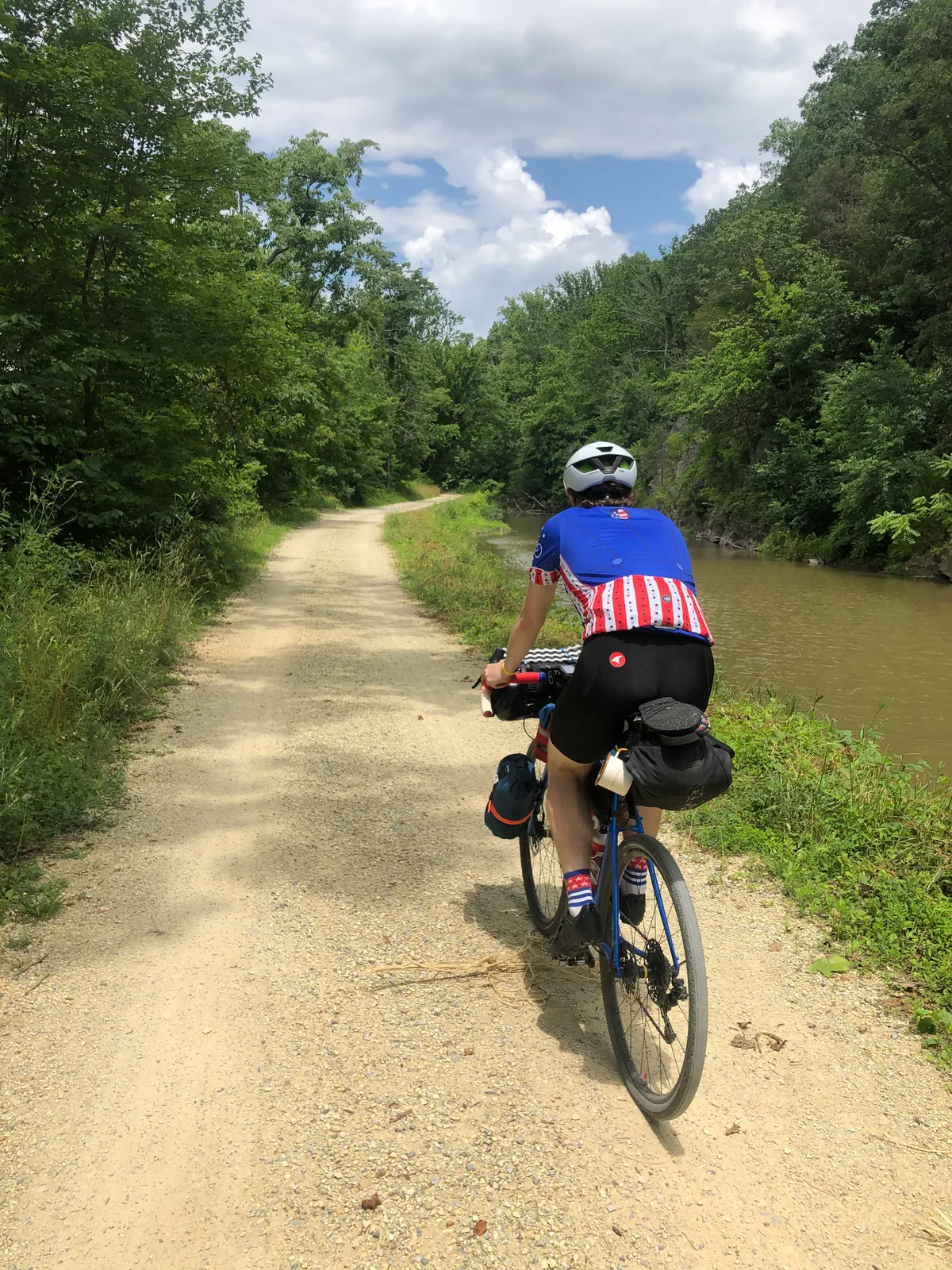 Dan riding away down the packed-gravel towpath beside the canal