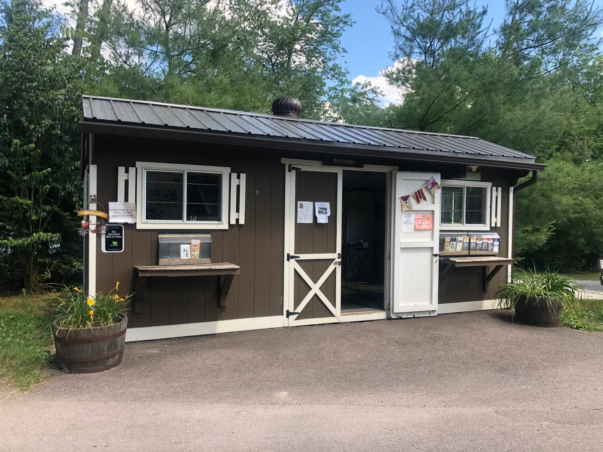 Small brown trailside info center with brochures and flower barrels