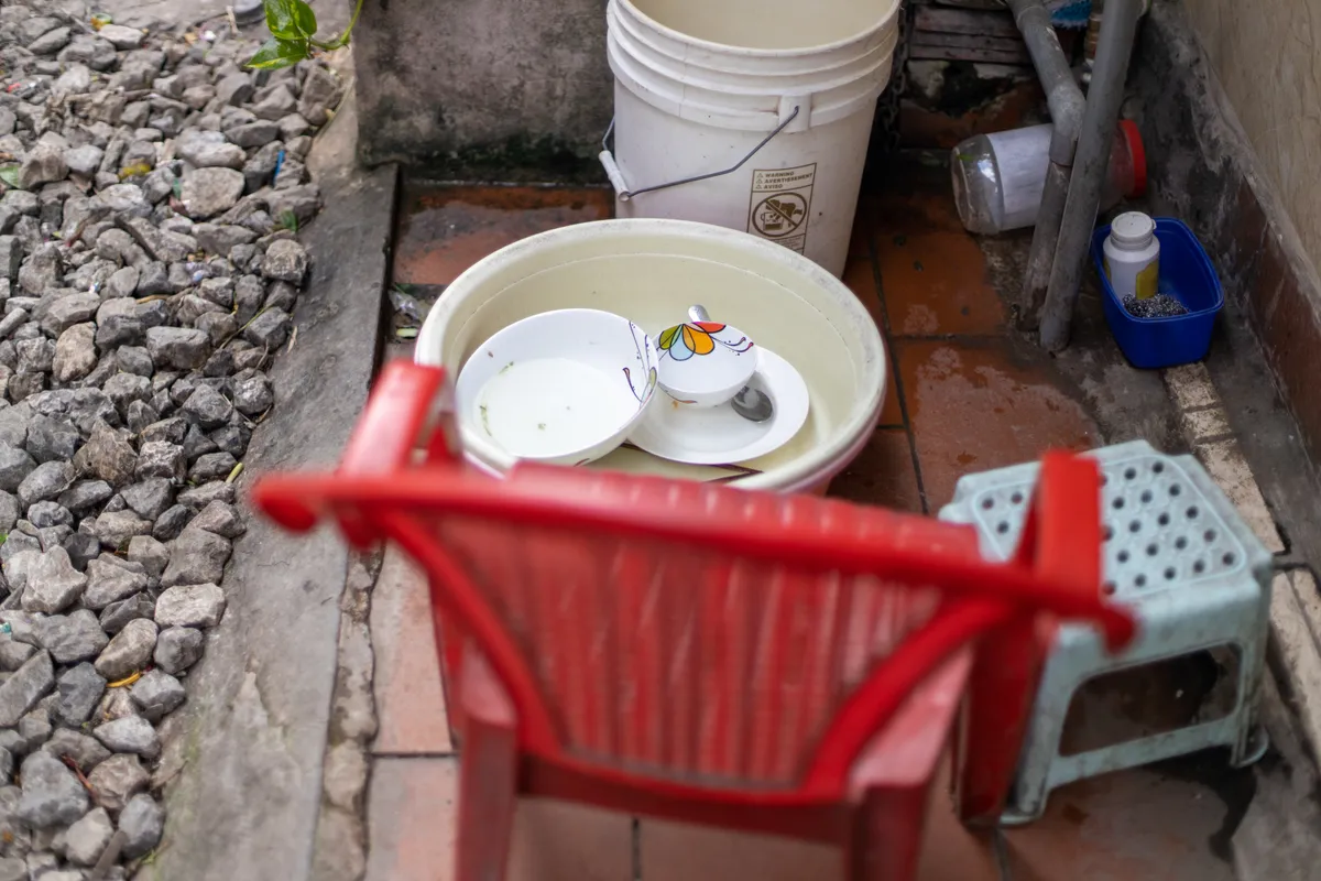 Bowls, a red chair and a stool set out on the edge of the tracks