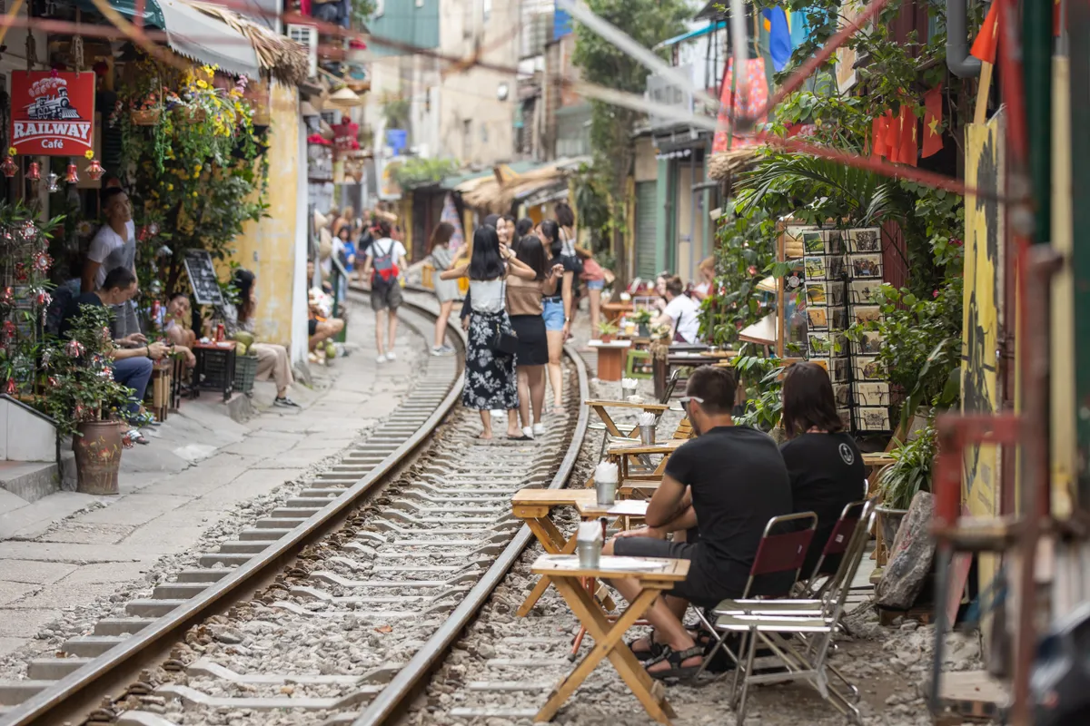 Cafes and tourists lining both sides of the tracks