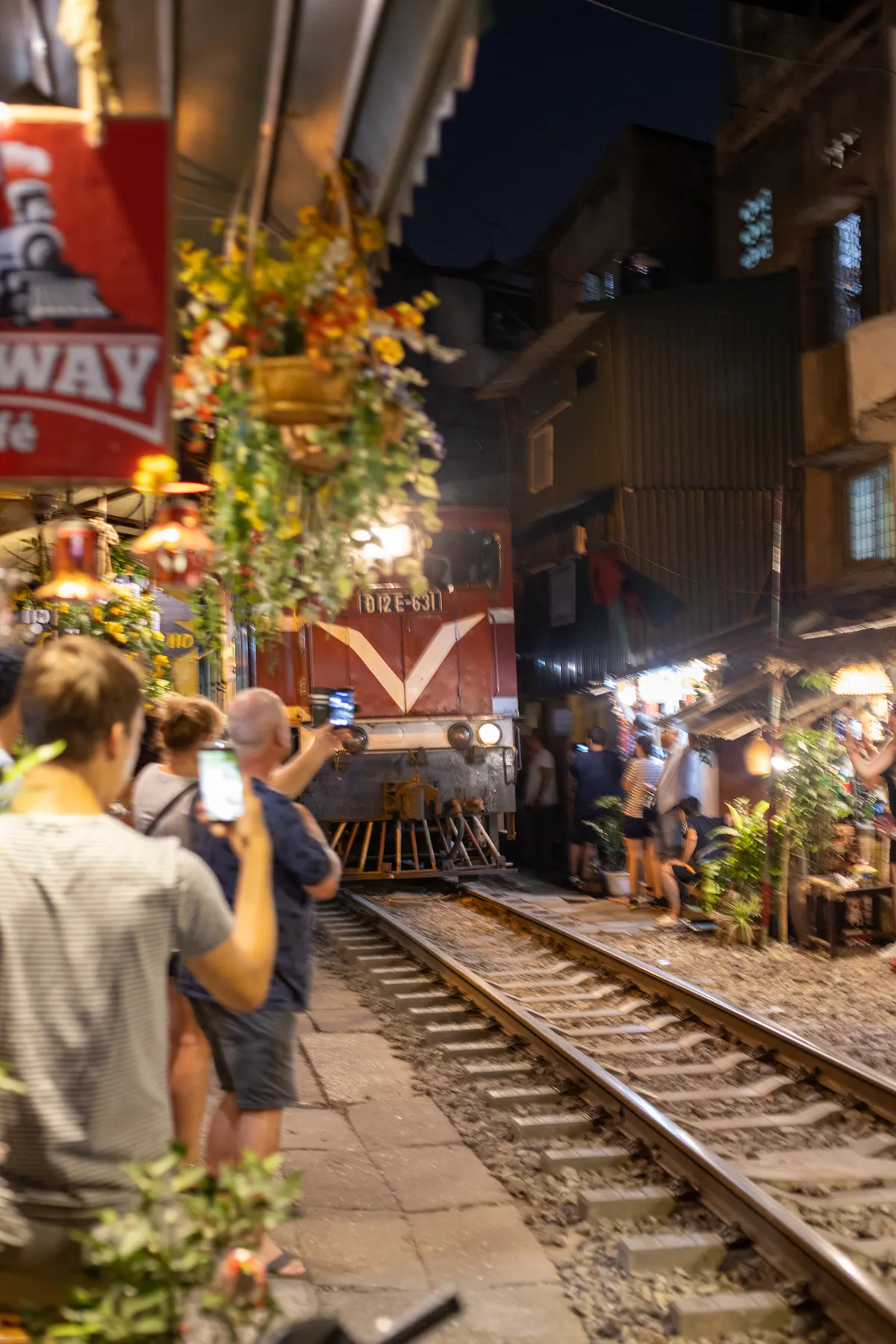 Train approaching at night as the crowd presses against the walls