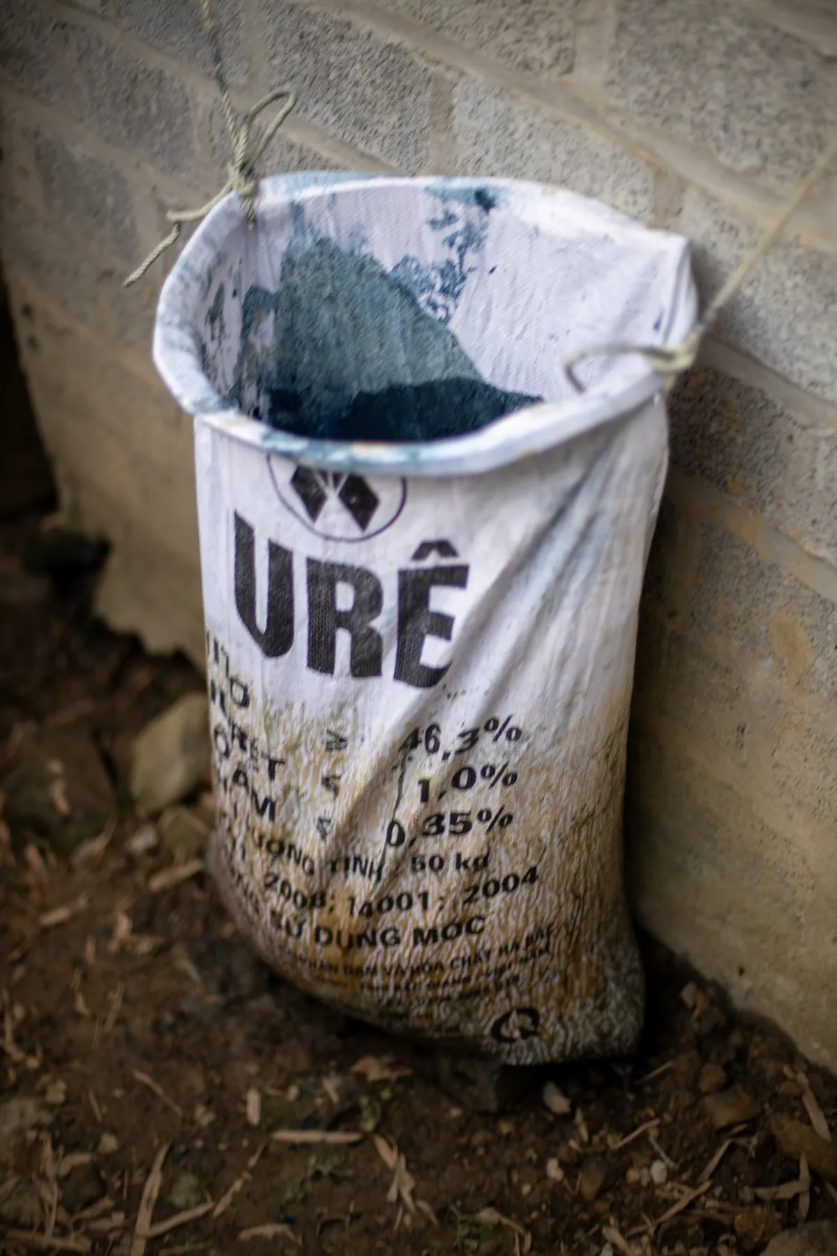Sack of crushed indigo powder leaning against a block wall