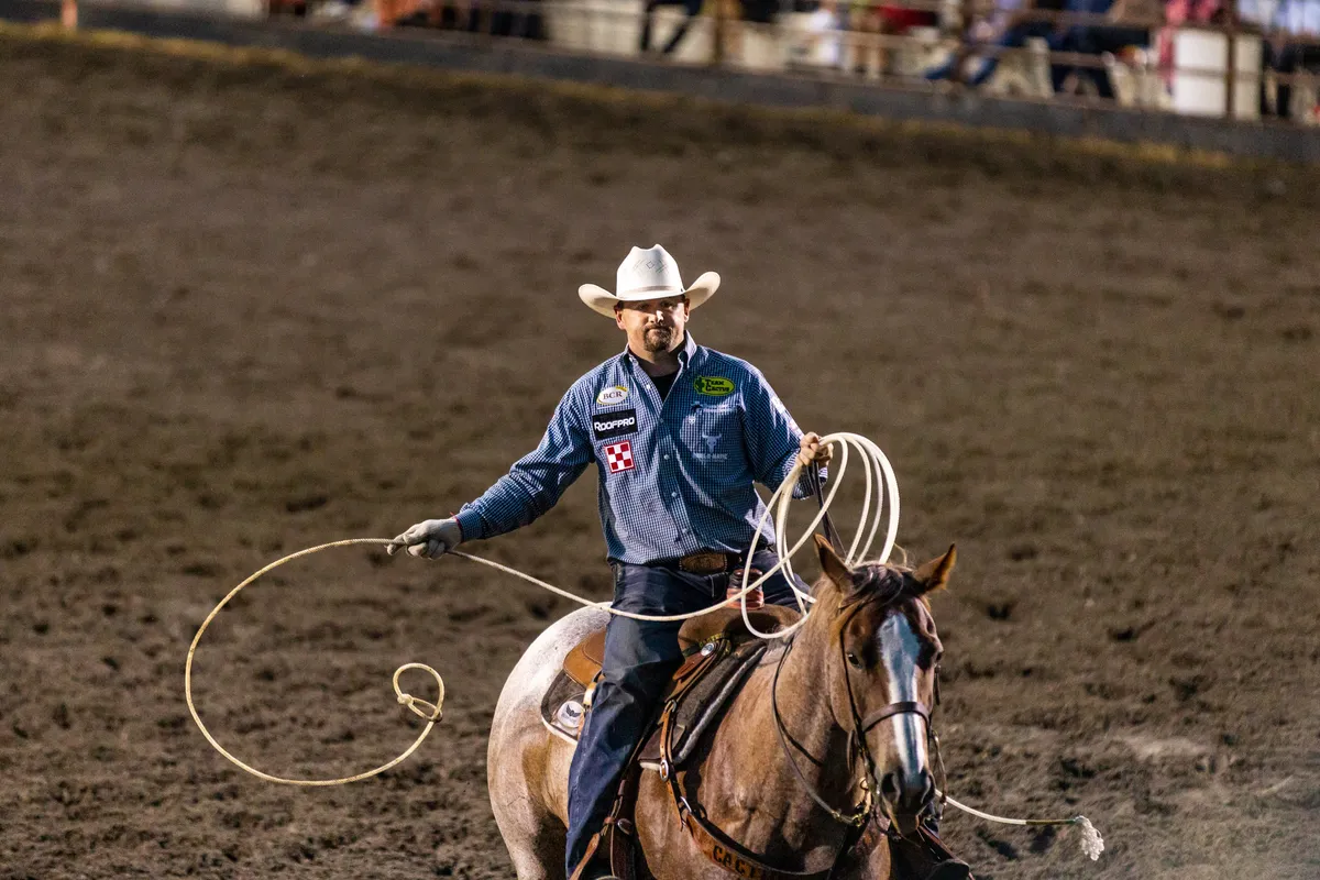 Roper on horseback shaking out a loop of rope