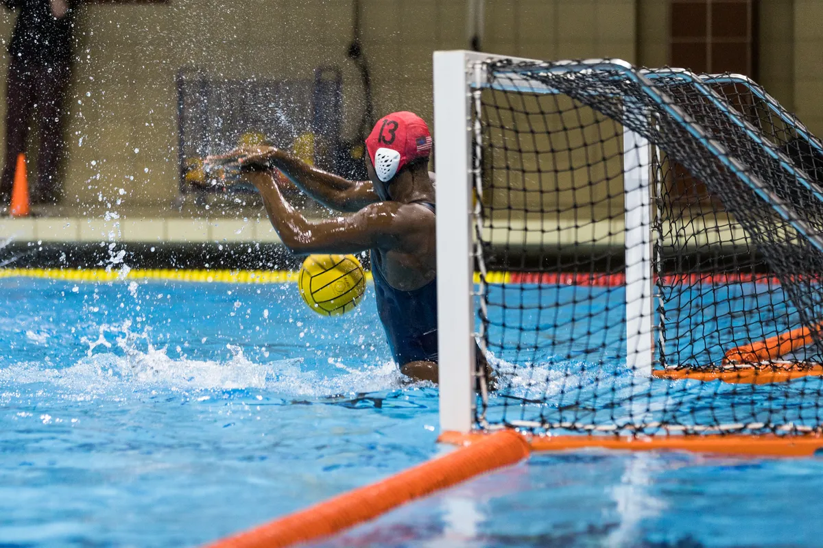 USA goalkeeper reaching back as the ball drops in front of the goal line