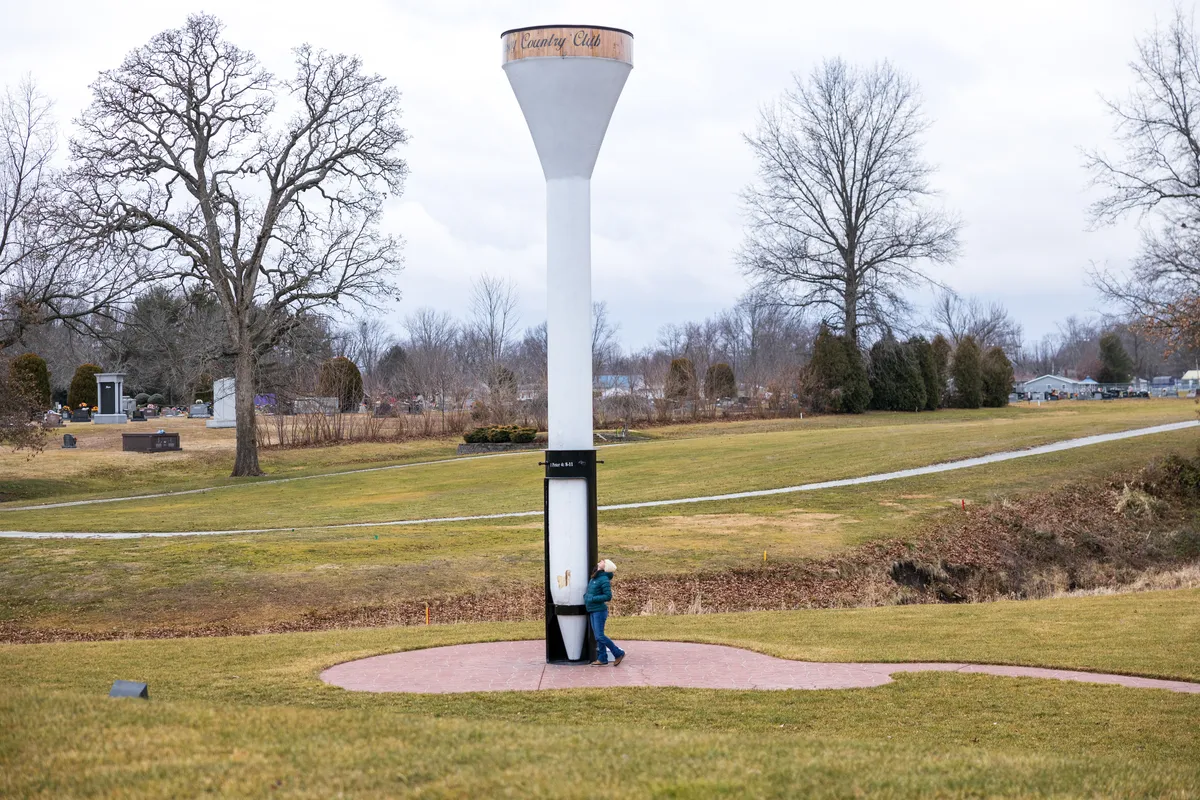Giant white golf tee standing in a grassy park
