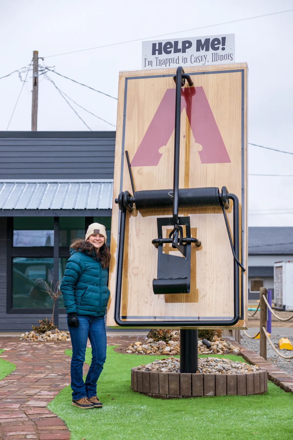 Visitor beside a giant mousetrap with a Help Me sign on top