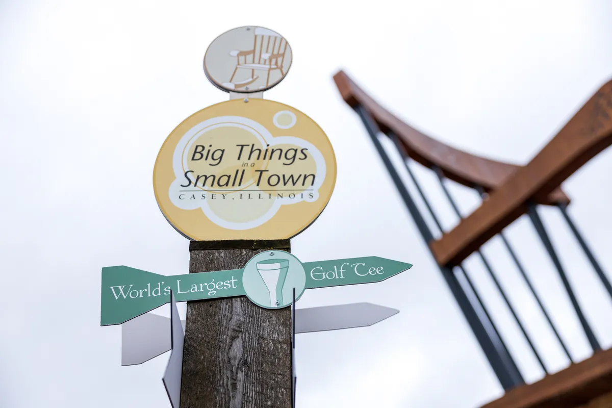 Big Things Small Town signpost with the giant rocking chair behind it
