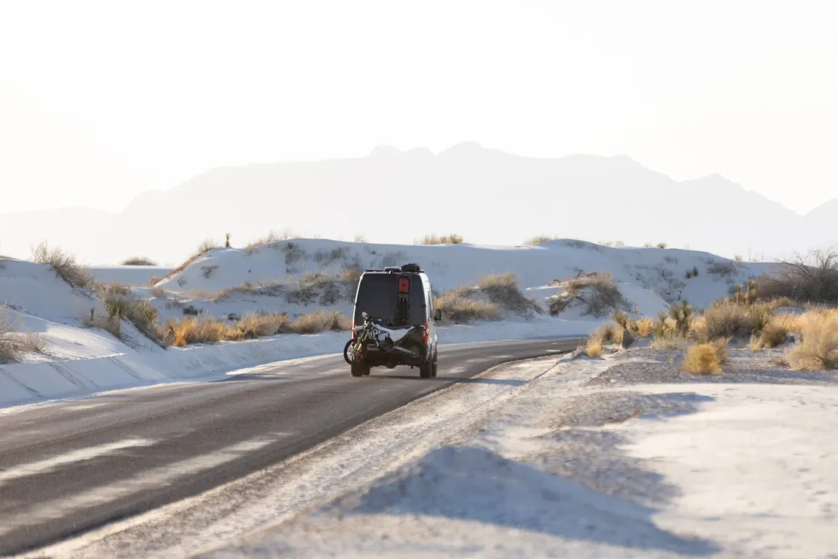Van on the dune road with mountains behind