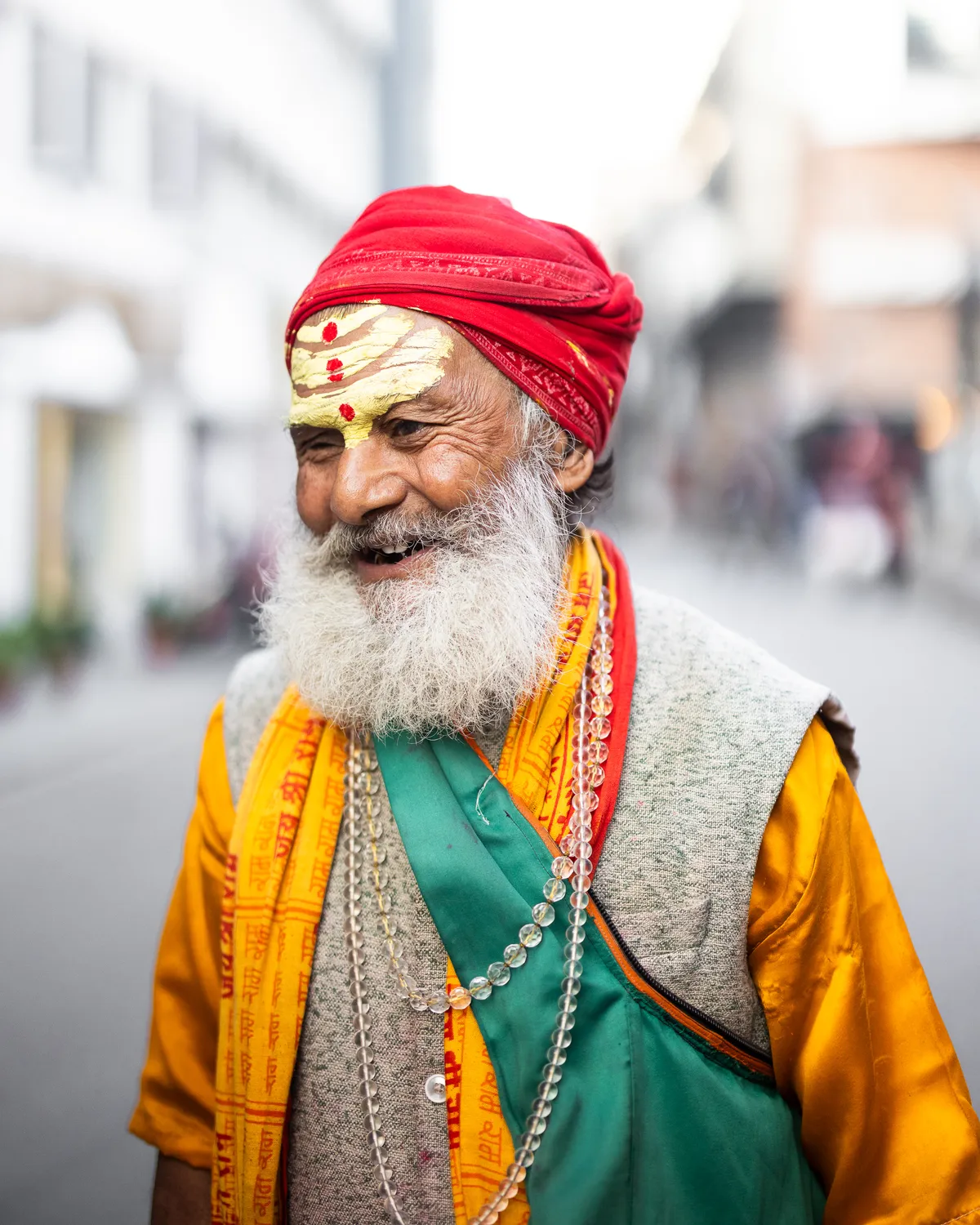 Smiling sadhu in a red turban and saffron robes